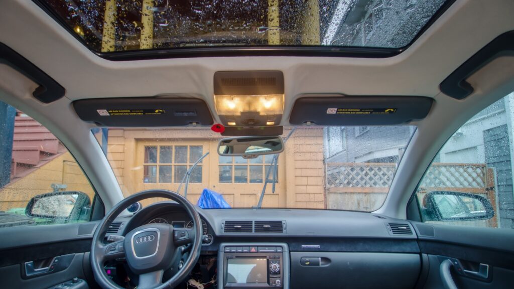 Inside of the car showing black sun shades against the grey head liner